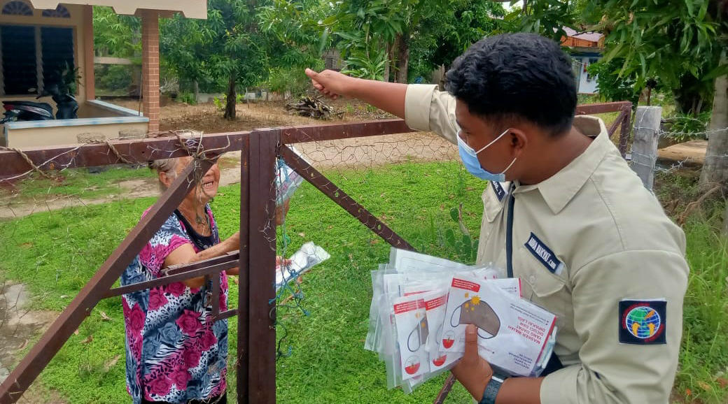 Salah seorang anggota IWO Karimun membagikan masker kepada seorang warga di Jl Pertambangan, Sei Ayam, Kecamatan Tebing, Senin (21/9/2020). (Foto: istimewa)
